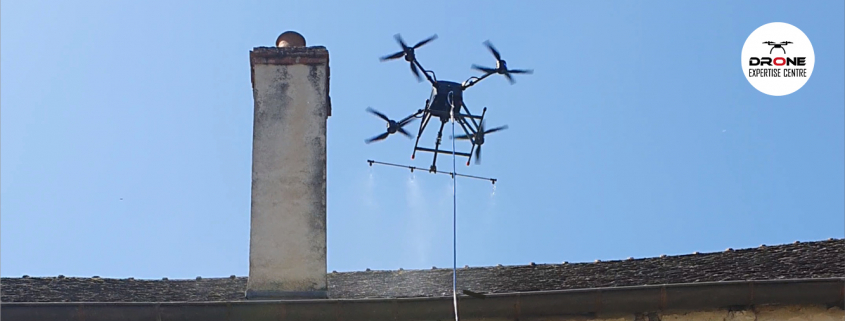 Photographie d'un drone réalisant un démoussage de toiture par drone