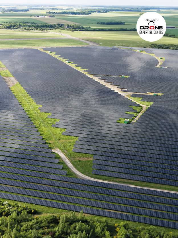 Inspection panneaux solaires par drone sur parc photovoltaïque en vue aérienne