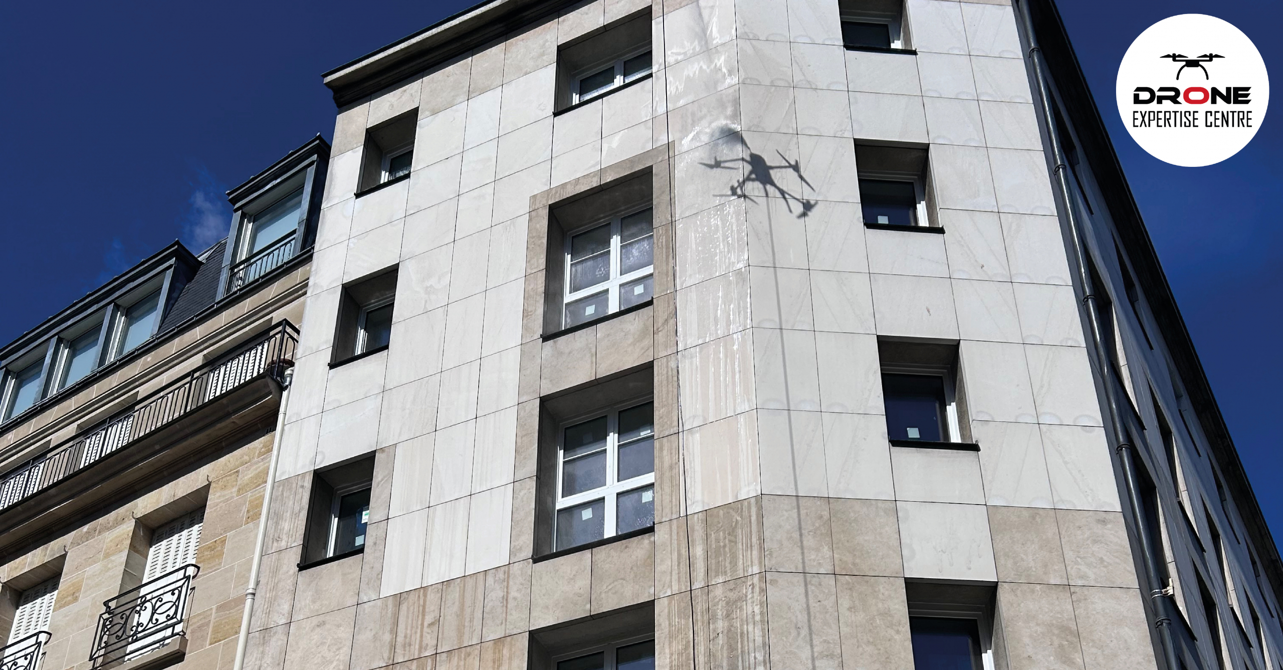 Démoussage par drone de façade sur un immeuble en pierre