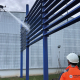 Démoussage par drone de façade avec pulvérisation d'un traitement nettoyant sur un bâtiment industriel en hauteur