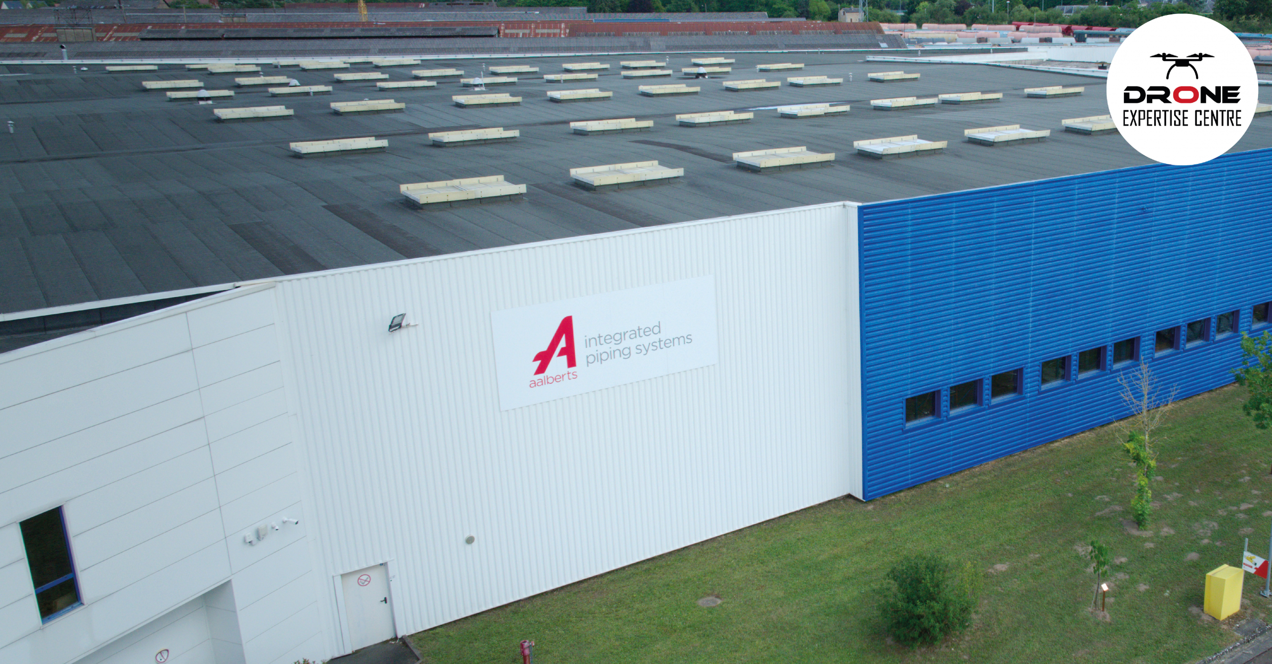 Démoussage par drone de façade sur plusieurs bâtiments industriels avec vue aérienne