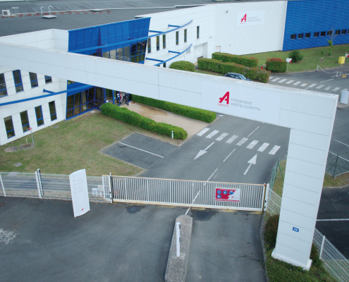 Démoussage par drone de façade appliqué à un grand bâtiment industriel vu en hauteur